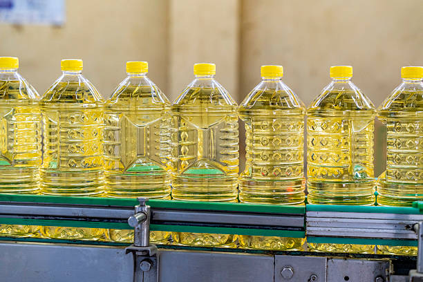 Bottles of Cooking Oil on a Production Line. Oil in bottles. Industrial production of sunflower oil. Conveyor line for bottling and packing. Sunflower oil plant.